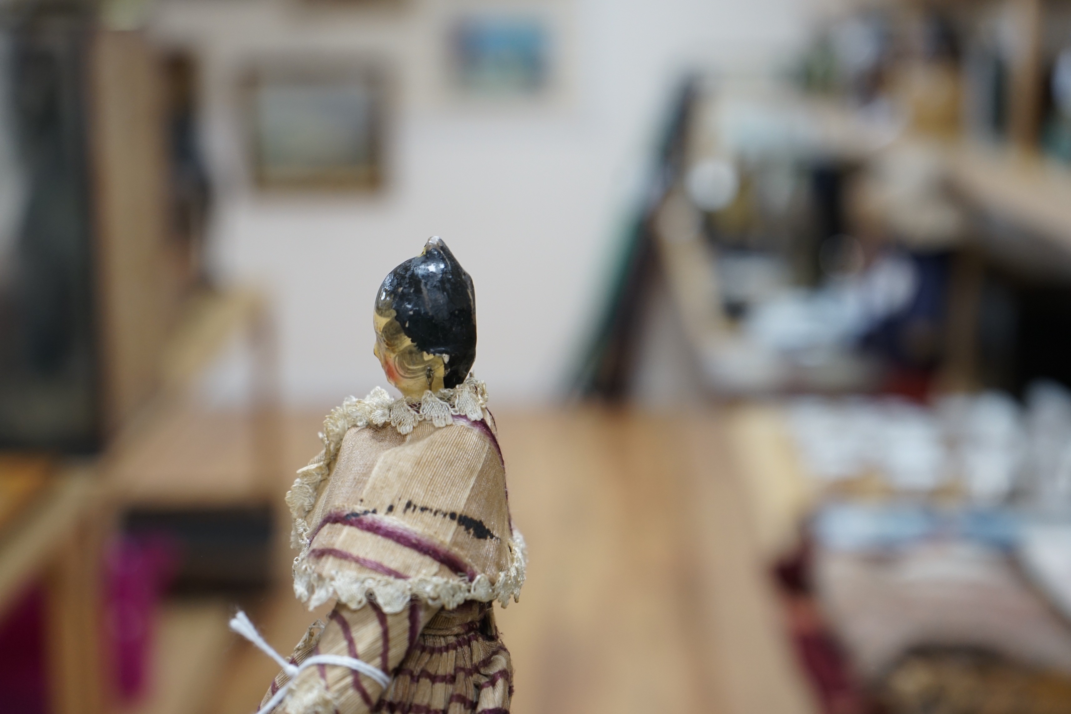 An early 19th century peg doll, wearing contemporary costume, 25.5 cm long